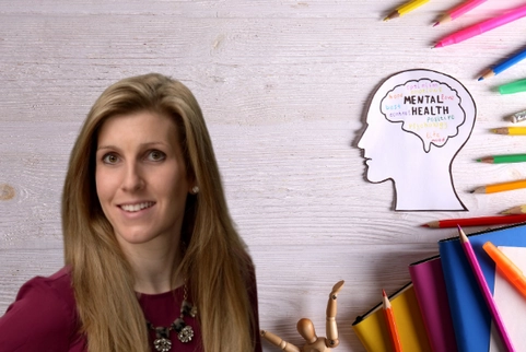 Dr. Cutitta standing in front of a backdrop of a person's brain with mental health written in crayon.