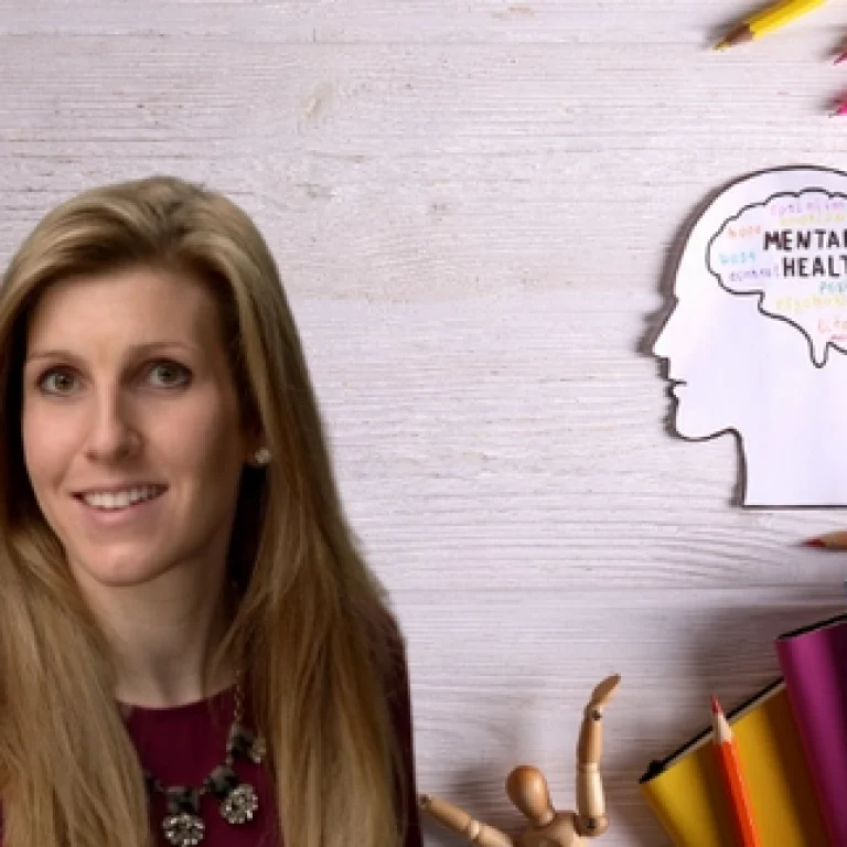 Dr. Cutitta standing in front of a backdrop of a person's brain with mental health written in crayon.